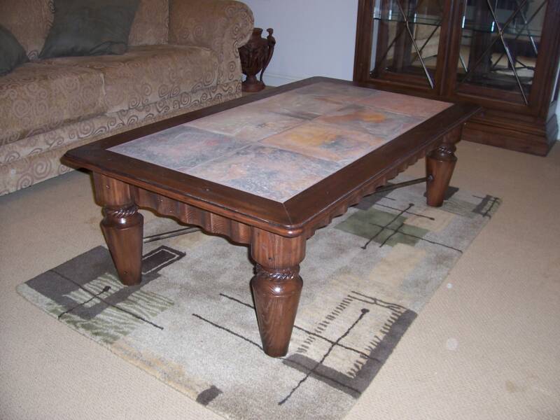 A glass top coffee table with a sleek refinished frame