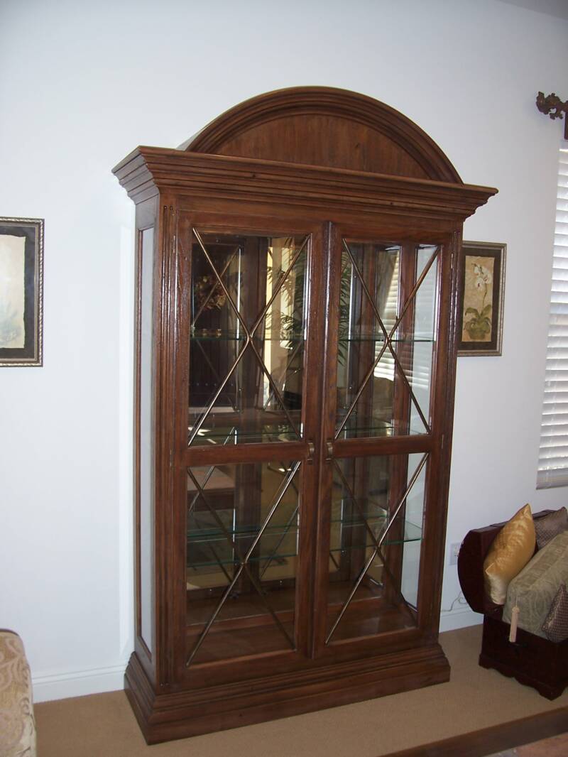 A large wooden cabinet with glass doors