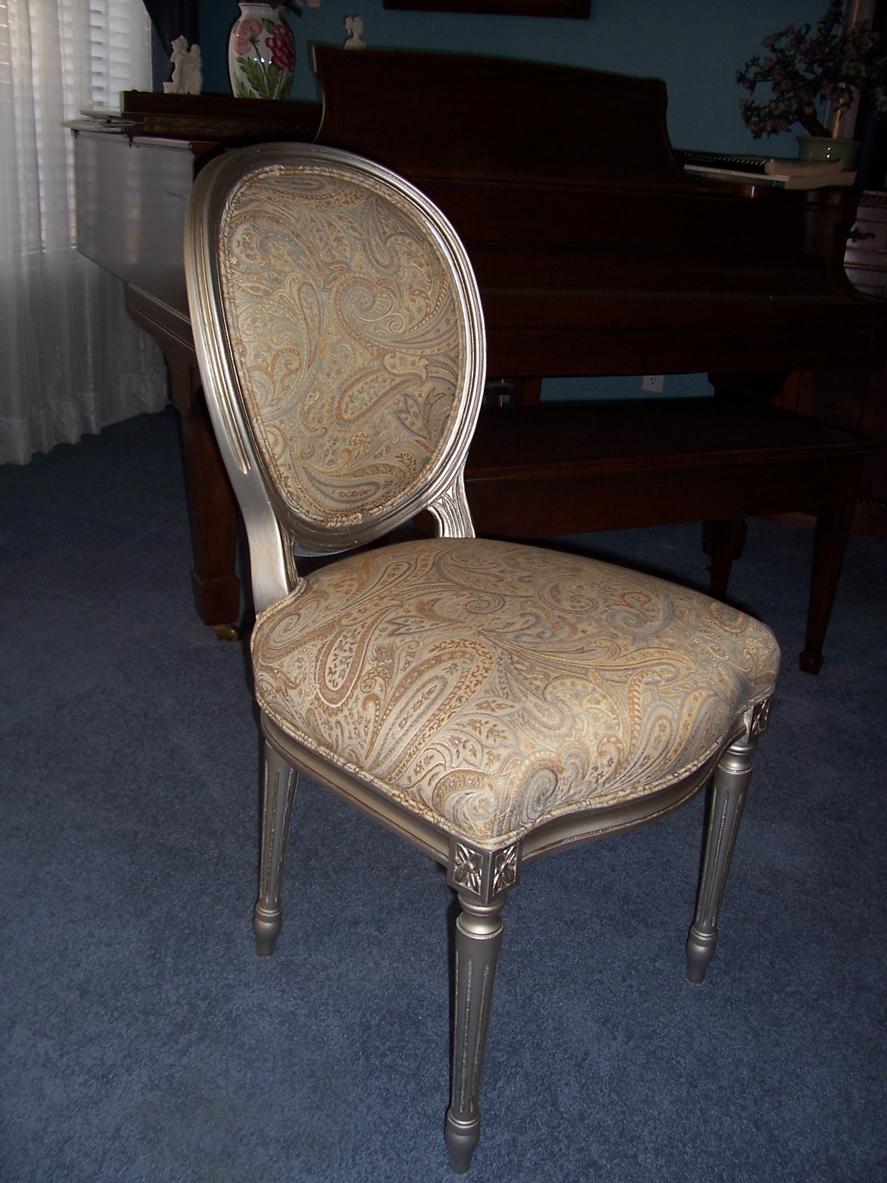 A paisley-patterned chair placed in a cozy room