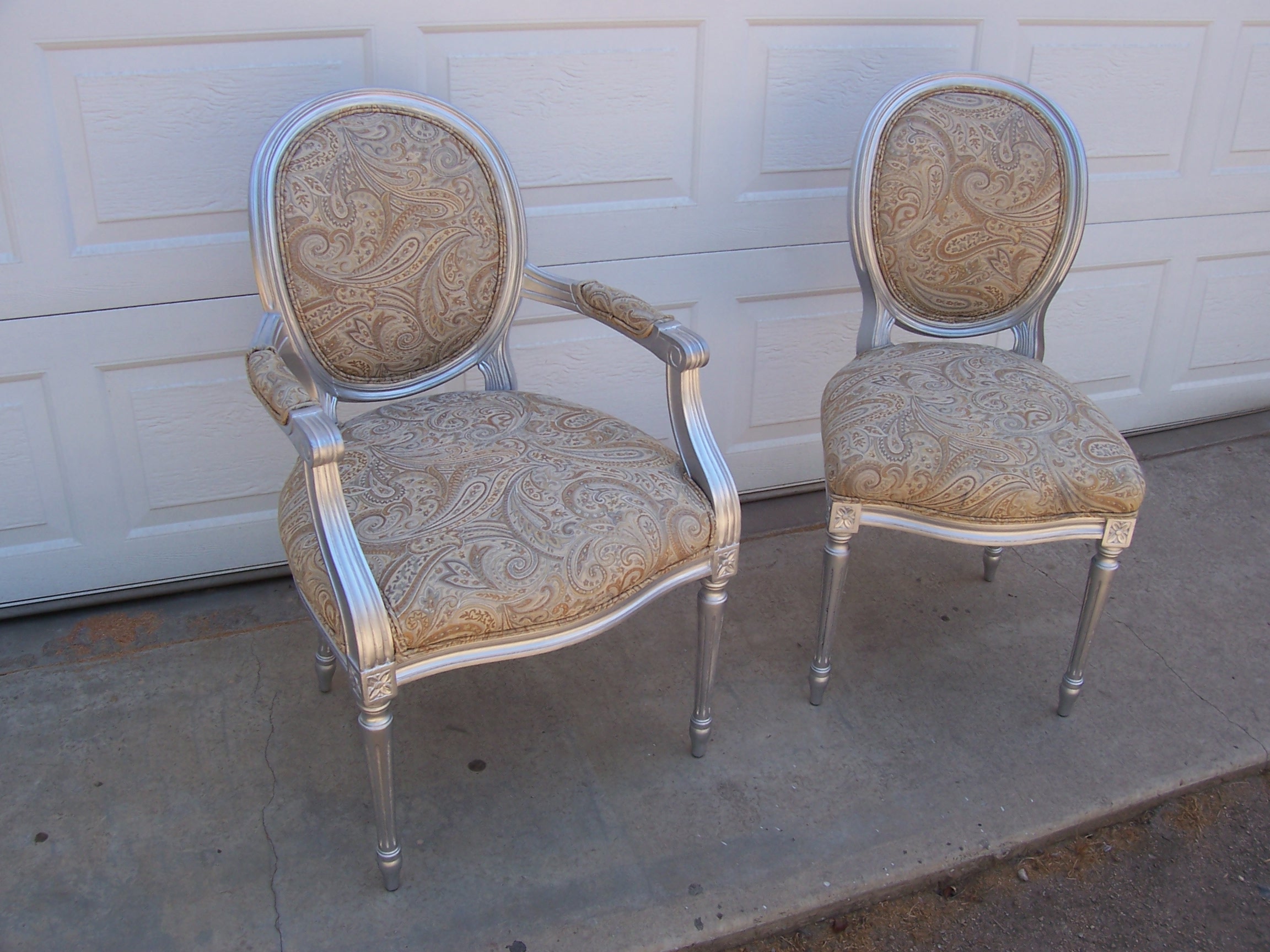 Two chairs with shiny silver seats, positioned side by side