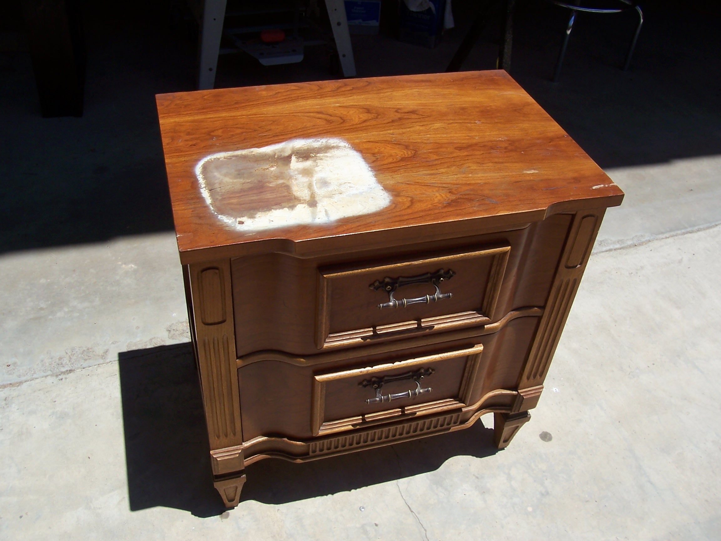 Wooden nightstand with two drawers sits on the floor